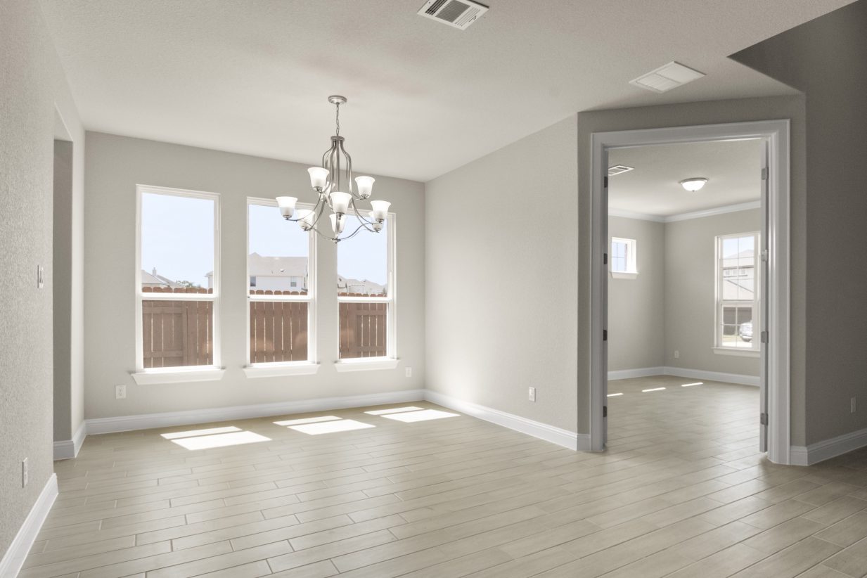 A dining room with vinyl flooring, white-framed windows, white painted walls, and pendants.