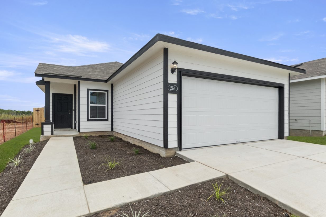 Image of front of a one story black and white home