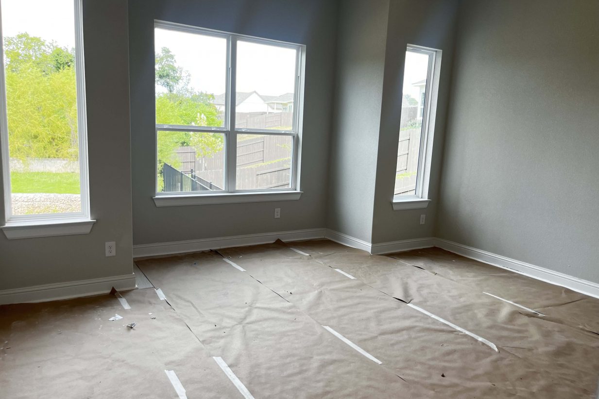 Room under construction with white framed windows and gray painted walls.