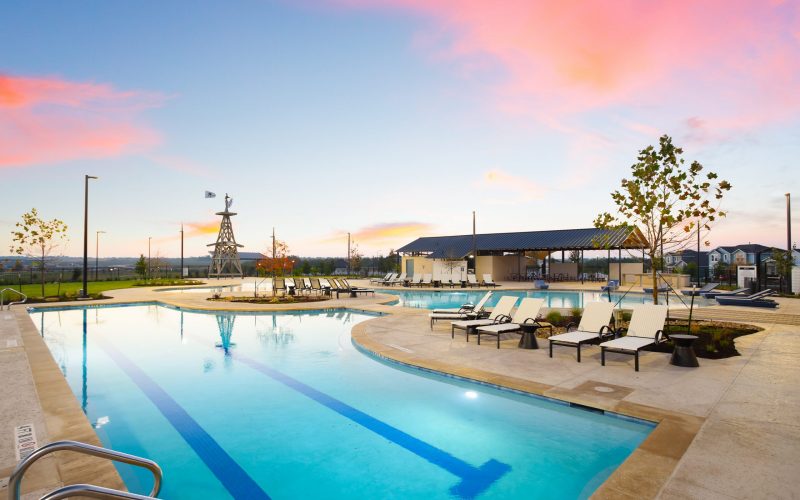 A large pool with lounge chairs and a sunset in the background at Harvest Ridge in Elgin
